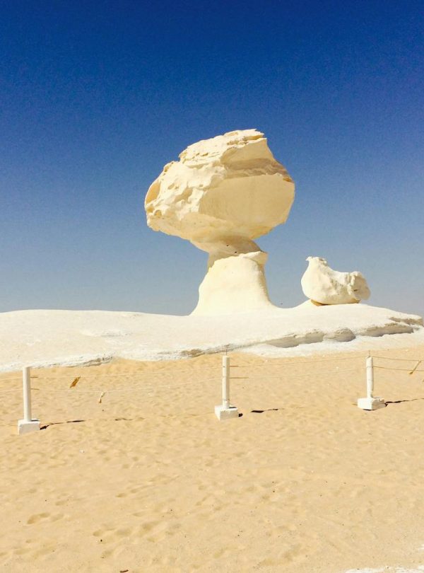 A striking rock formation in Egypt's White Desert under a blue sky.