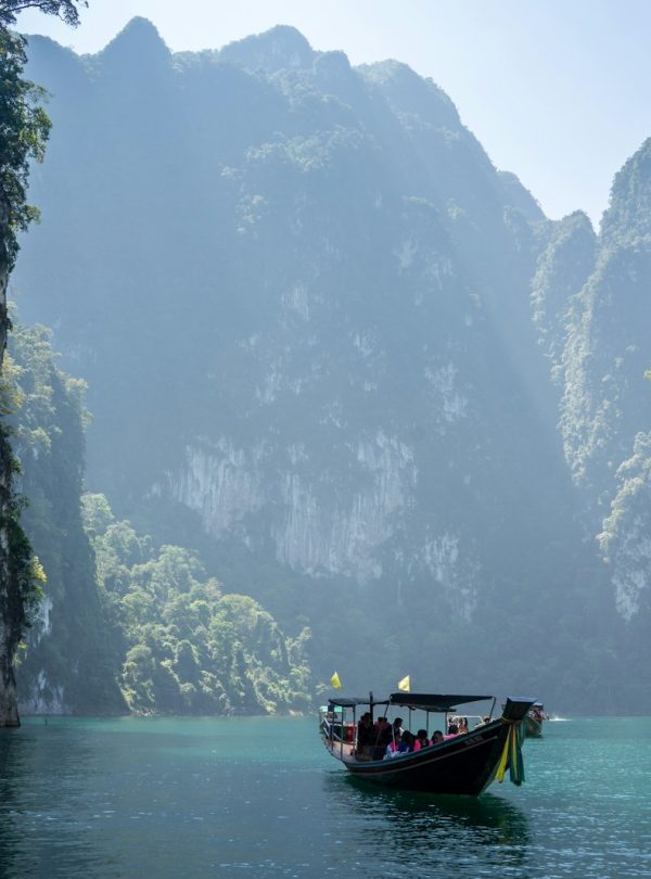 white boat in between rocky mountains